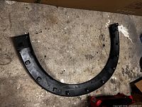 Interior view of black plastic left fender flare showing mounting points