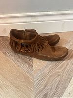 Side view of both moccasins showing fringe and general condition