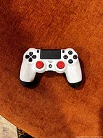 Front view of custom white DualShock 4 with red thumbsticks