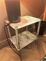 Full view of two-tier table showing both shelves and aluminum legs