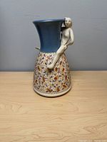 front view showing blue neck, patterned body, attached figure