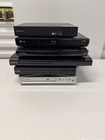 Stack of five Sony and LG disc players