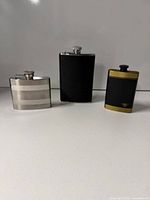 Three flasks standing side by side on countertop