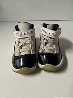 Front view of toddler Air Jordan 11 sneakers showing uppers, strap and toe condition
