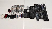 All remote controls, two mice and small speaker laid out on table