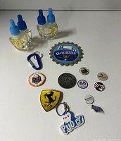 Overview of assorted small items including refill bottles, patch, keychain, pins and tokens