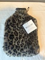 Front view of leopard print faux fur hot water bottle with tag visible
