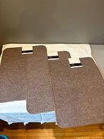 Three brown Nova Mats laid out showing size and shape