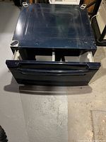 Pedestal with drawer partially open showing interior