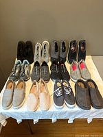 Overview of 12 pairs of shoes arranged on table