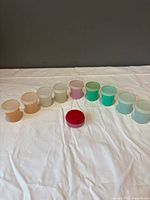 All ten Tupperware containers arranged on cloth showing colors and lids