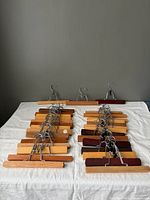 31 assorted wood pant hangers laid out on table
