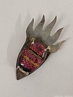 front view of silver brooch with multicolour glass cabochon