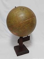 Full view of globe on wooden stand