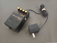 Top view of Boss HM-2W pedal and power adapter