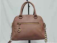 Front view of ballet pink leather satchel showing handles, front zip pocket, MK charm and chain strap