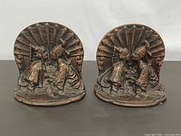 Front view of both bronze bookends showing Asian lovers relief