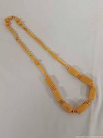 Full view of yellow Bakelite necklace laid flat