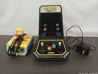 Front view of tabletop arcade, plug-n-play joystick and power adapter