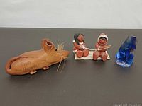 Four items: bread mouse, Indigenous figurine, blue glass sculpture