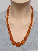 Necklace worn on mannequin showing graduated beads