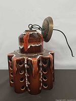 front view of glazed ceramic pendant lamp with openings and canopy