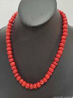 Front view of red coral bead necklace on display bust