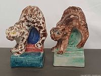 Front view of both ceramic cat statues showing colours and condition
