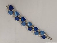 Top view of bracelet showing alternating blue thermoset stones in silver-tone links