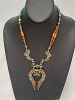 Full view of turquoise and coral beaded necklace on display bust