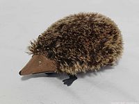 Front-side view of faux fur covered hedgehog toy showing snout and eyes