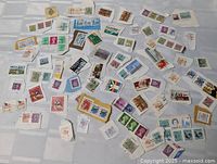 Full spread of assorted loose postage stamps