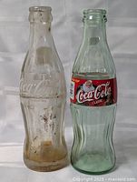 Front view of both Coca-Cola contour bottles side by side