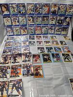 Overview of multiple sheets of blue-border football and hockey cards