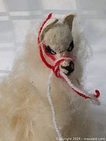 Front view of wool llama showing head, yarn halter and wool texture
