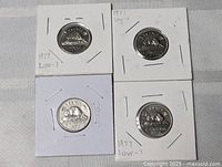 Group of four Canadian 5-cent coins in holders