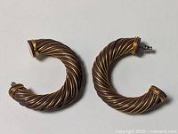 Both chunky twisted copper-tone hoop earrings side by side