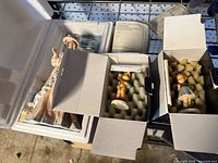 Three boxed porcelain figurines: lady figure in styrofoam, two Hummel figures in cartons