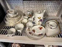 Overall view of dinnerware on shelf showing two patterns and item quantities
