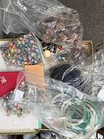 Overview of box with multiple bags of beads and bangles