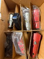 Six tin toy train pieces in partitioned box