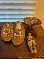 Overall lot with moccasins, basket, Skookum doll