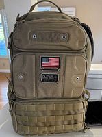 Front view of khaki G.P.S. Tactical Range Backpack showing patch panel, MOLLE webbing, main compartments