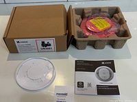 Box contents showing alarm, packaging tray, user guide and box label