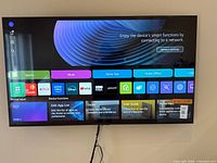 front view of powered-on 65-inch LG smart TV mounted on wall