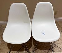 Front view of both white molded chairs