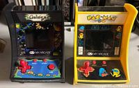Front view of both Pac-Man (yellow) and Galaga (black) mini arcade machines