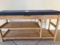 Front view showing two slatted shelves and upholstered lid