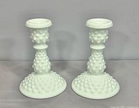 Full view of both hobnail milk glass candlesticks