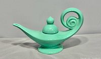 Full view left side of mint green ceramic Aladdin teapot with lid